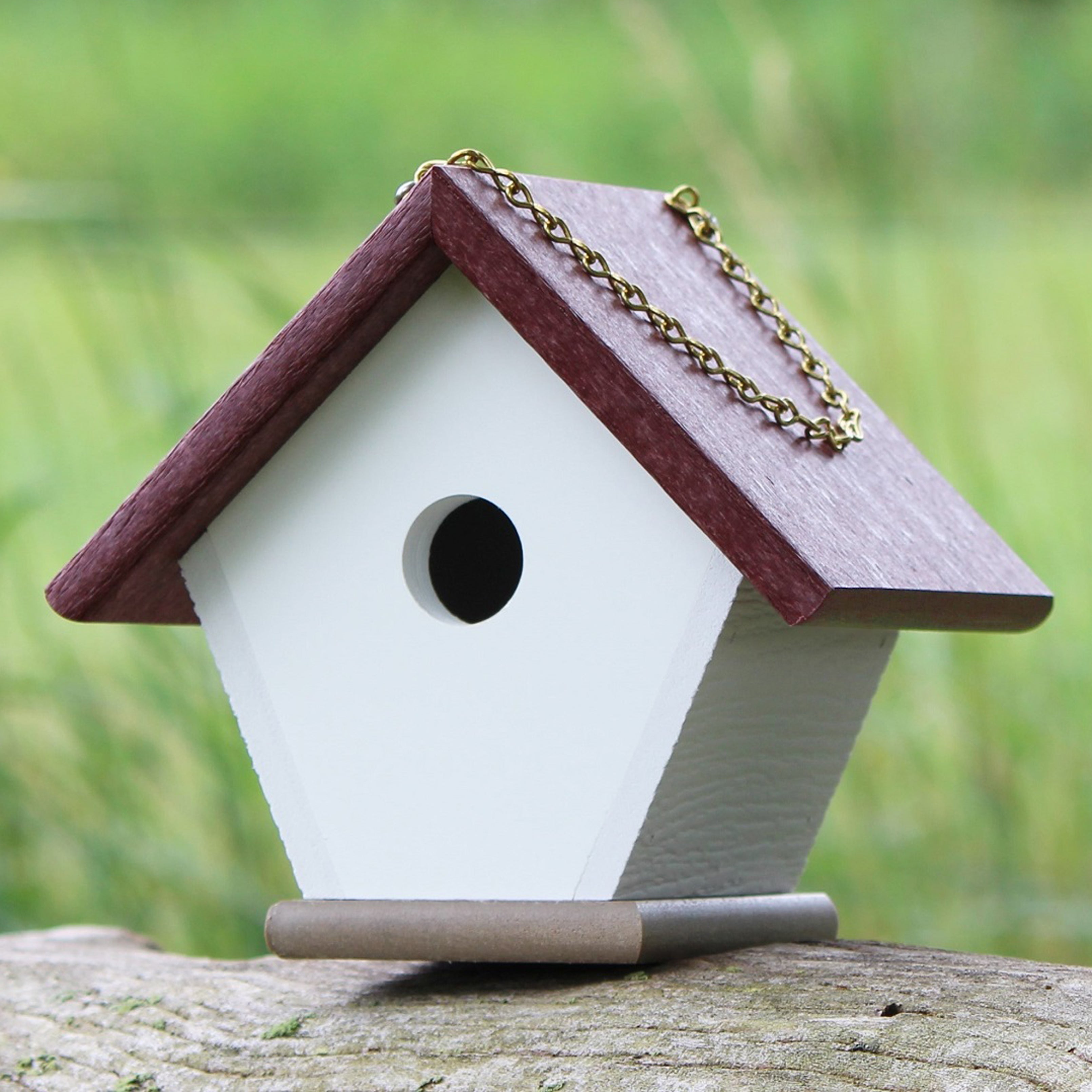 Cherry wren house sitting on log